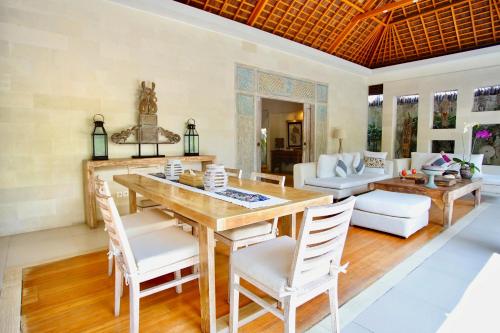 a dining room with a wooden table and chairs at Villa Bali Asri Batubelig in Seminyak
