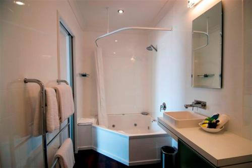 a bathroom with a tub and a sink and a shower at Marineland Beachfront Accommodation in Napier
