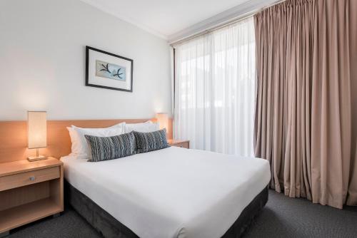 a hotel room with a large bed and a window at Franklin Apartments in Adelaide
