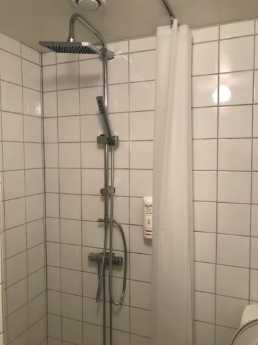 y baño con ducha y cortina de ducha. en Klackbergsgården en Norberg