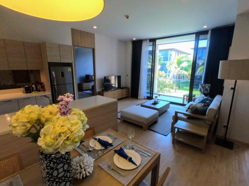 a living room with a vase of flowers on a table at Baan Mai Khao condo in Mai Khao Beach