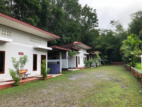une rangée de cottages dans un complexe dans l'établissement Thanathorn Guesthouse, à Trang