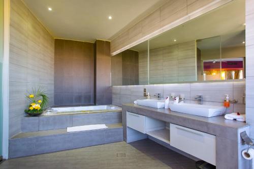 a bathroom with two sinks and a tub at Bliss Resort in Nyali