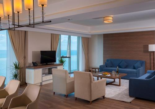 a living room with a blue couch and a tv at Ramada Plaza by Wyndham Rize in Rize