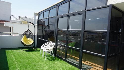 a balcony with a chair and some grass at Daffodil Delight - Manyata Tech Park in Bangalore