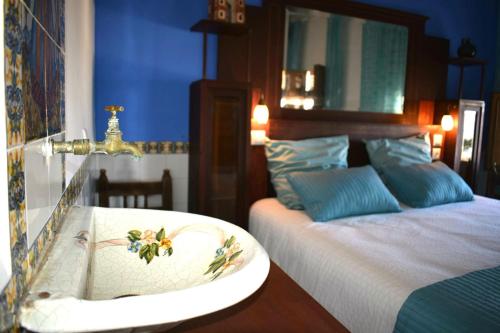 een badkamer met een wastafel en een bed met een spiegel bij Charming house in the historic old town in Alicante