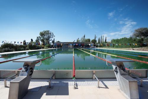 uma grande piscina de água com bancos à sua frente em Kolderen Coral Bay 6 em Coral Bay