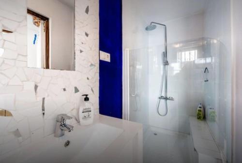een witte badkamer met een douche en een wastafel bij Charming house in the historic old town in Alicante
