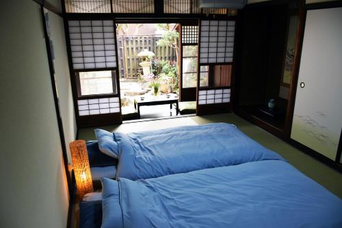 um quarto com duas camas num quarto com uma janela em Guesthouse Mio em Omihachiman