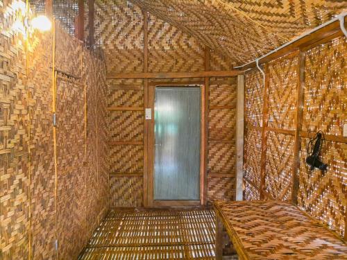 Zimmer mit einer Tür in einer Strohmauer in der Unterkunft Rain Forest Inn in Ringlet