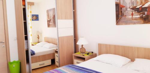 a small bedroom with two beds and a mirror at Pjerotic Apartment in Budva