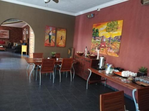 a restaurant with a dining room with a table and chairs at 24 Onvrey Guest House in Boksburg
