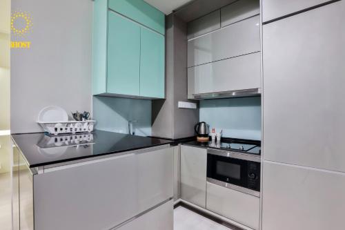 a kitchen with white cabinets and a sink at Expressionz Suites By iHost Global in Kuala Lumpur