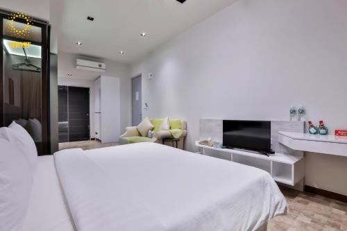 a white bedroom with a large bed and a tv at Expressionz Suites By iHost Global in Kuala Lumpur