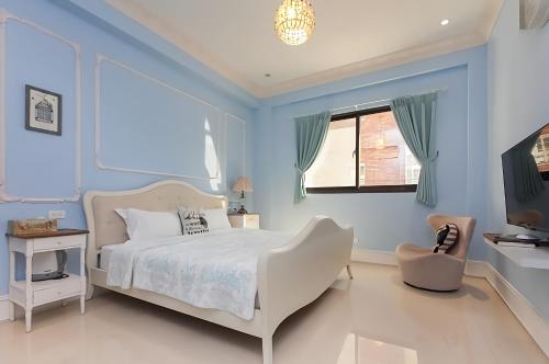 a blue bedroom with a bed and a window at French Cotton Candy in Jian