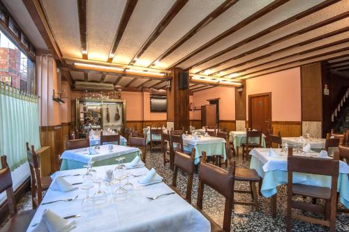 a dining room with tables and chairs with blue tablecloths at Hostal Restaurante El Castillo in Alcorisa