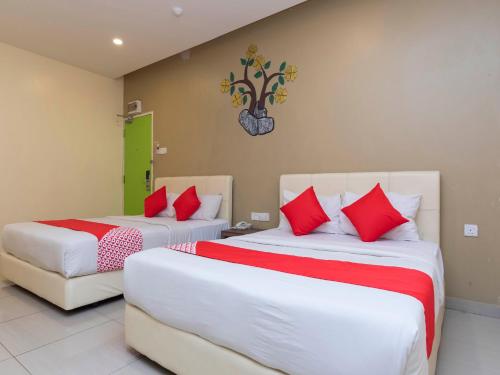 two beds in a room with red and white pillows at I Leaf Boutique Hotel in Johor Bahru