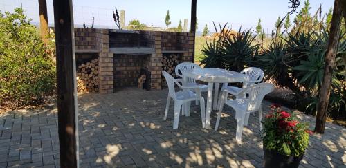 a white table and chairs on a brick patio at Forest Hill Country Lodge in Piet Retief