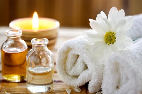 a towel and a candle and a bottle of essential oil at Noni Tree Hostel in Siem Reap