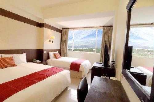 una camera d'albergo con due letti e una finestra di FlowerSay Homestay a Ji'an