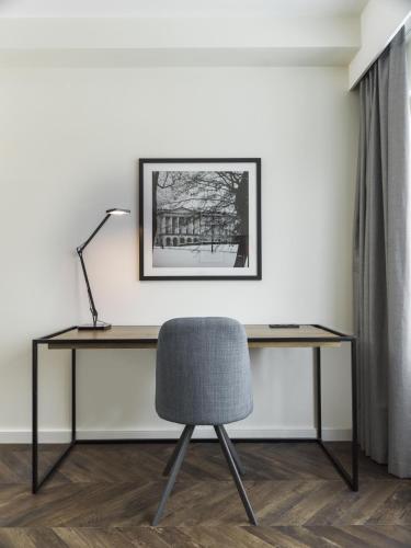 a desk with a chair and a lamp at Radisson Blu Hotel Nydalen, Oslo in Oslo