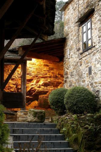 a stone building with stairs in front of a building at La Rectoral in Taramundi
