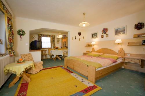 a bedroom with a bed and a living room at Haus Alpenglühn in Abtenau