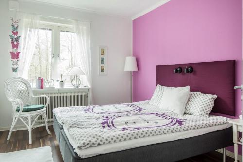 una camera da letto viola con un letto con parete viola di Landvetter BnB a Härryda
