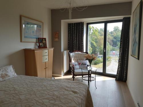 sypialnia z łóżkiem, krzesłem i oknem w obiekcie Praha Karibik w Pradze