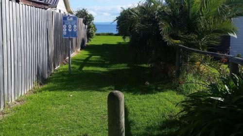 a yard with a fence and a sign in the grass at 4 Bounty in Corinella