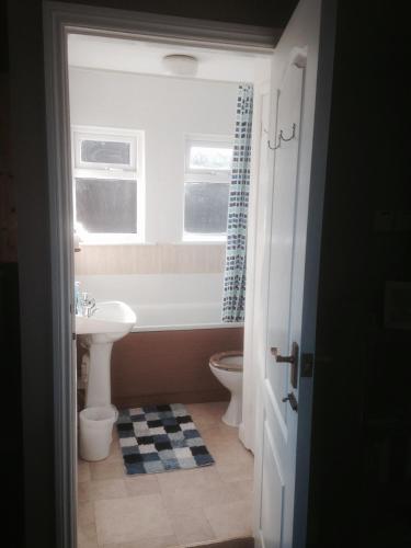 a bathroom with a sink and a toilet and a window at The Snug Ilfracombe in Ilfracombe