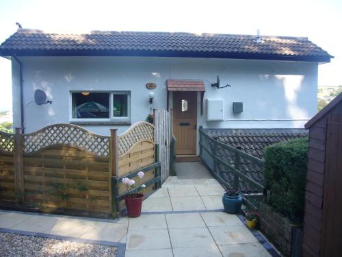 a house with a wooden fence and a porch at The Snug Ilfracombe in Ilfracombe