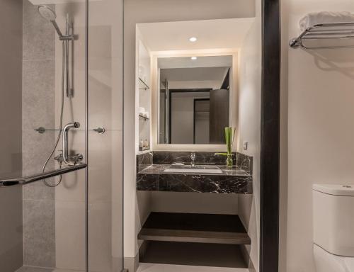 La salle de bains est pourvue d'un lavabo et d'un miroir. dans l'établissement Seda Ayala Center Cebu, à Cebu