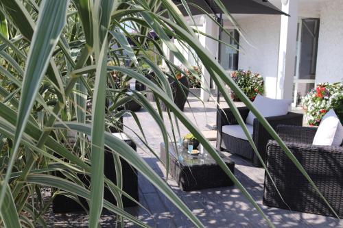 a patio with chairs and a table and plants at Village Vacances de Chantonnay in Chantonnay