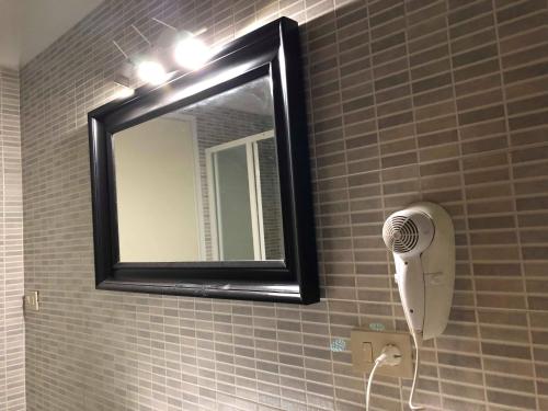 a bathroom with a mirror and a hair dryer at Il Galileo Rooms in Pisa