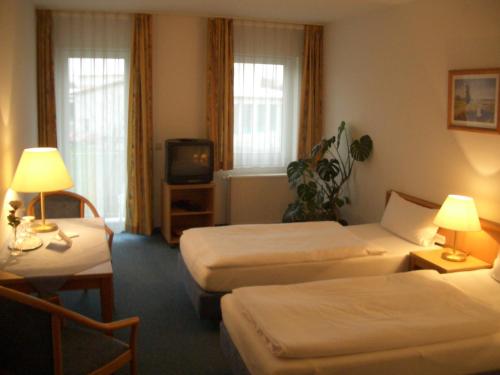 a hotel room with two beds and a tv at Weinhotel Wagner in Frankenthal