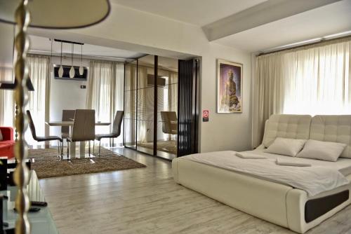 Un dormitorio con una cama y un comedor. en Eric Apartment 100, en Bucarest