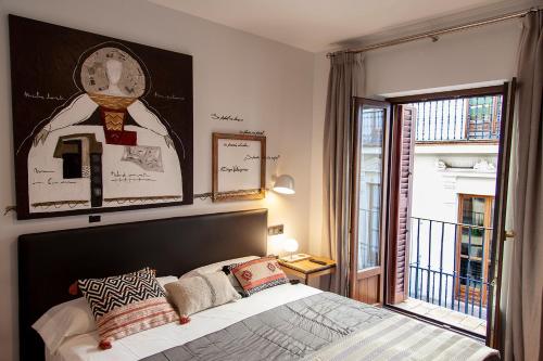 a bedroom with a bed and a large window at Welldone Placentines in Seville