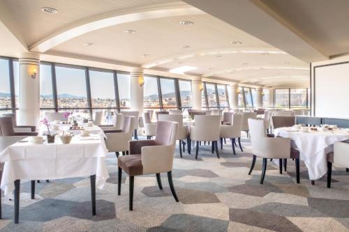 a dining room with tables and chairs and windows at Sofitel Marseille Vieux-Port in Marseille