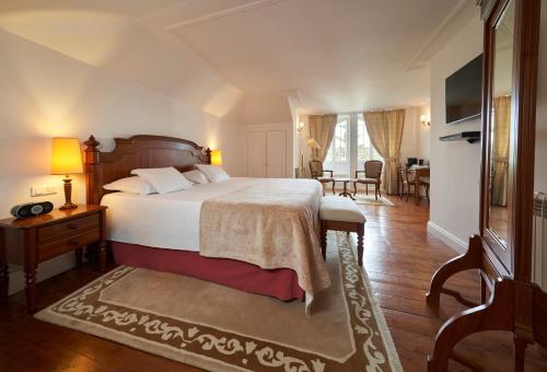 a bedroom with a bed and a living room at PortoBay Serra Golf in Santo António da Serra