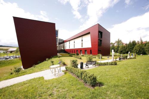 a red and white building on a grass field at Spa Hotel Bründl in Bad Leonfelden