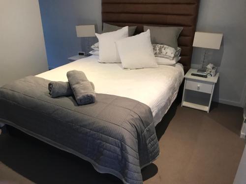 a bedroom with a large bed with white sheets and pillows at Marina View Apartment on the Maribyrnong River, Melbourne in Maribyrnong