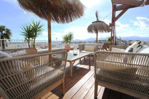 a patio with chairs and a table and umbrella at Bleu Mer Duplex & Suites in Saint-Cyprien