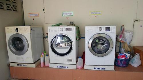 three washing machines and a dryer in a room at Wandee Resort Bankrut in Ban Krut