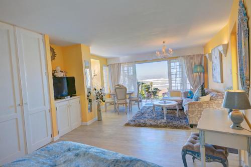 a living room with yellow walls and a living room with a couch at Haus am Strand - on the Beach in Wilderness