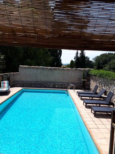 une piscine avec des chaises longues à côté dans l'établissement Chambres d'hôtes La Chabrière, à Cliousclat