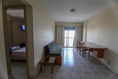 a room with a couch and a table and a bed at Hotel Vila Rica Flat in Resende