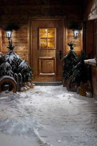 a house with two christmas trees in front of a door at Berghaus Alpenrösli in Klosters