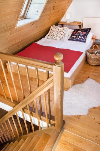 a bed in a wooden room with a window at Apartament Olczanka Zakopane in Zakopane