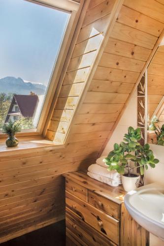 an attic bathroom with a sink and a window at Apartament Olczanka Zakopane in Zakopane